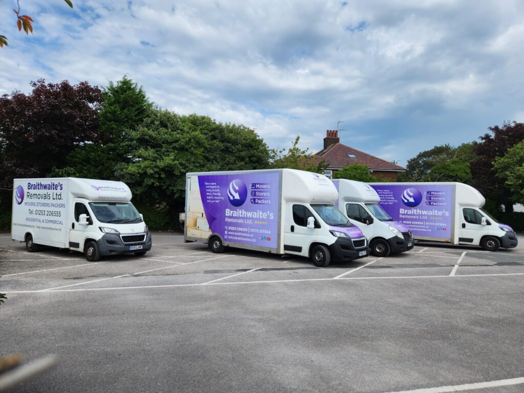 Large house removal – multiple vans and movers handling household items.