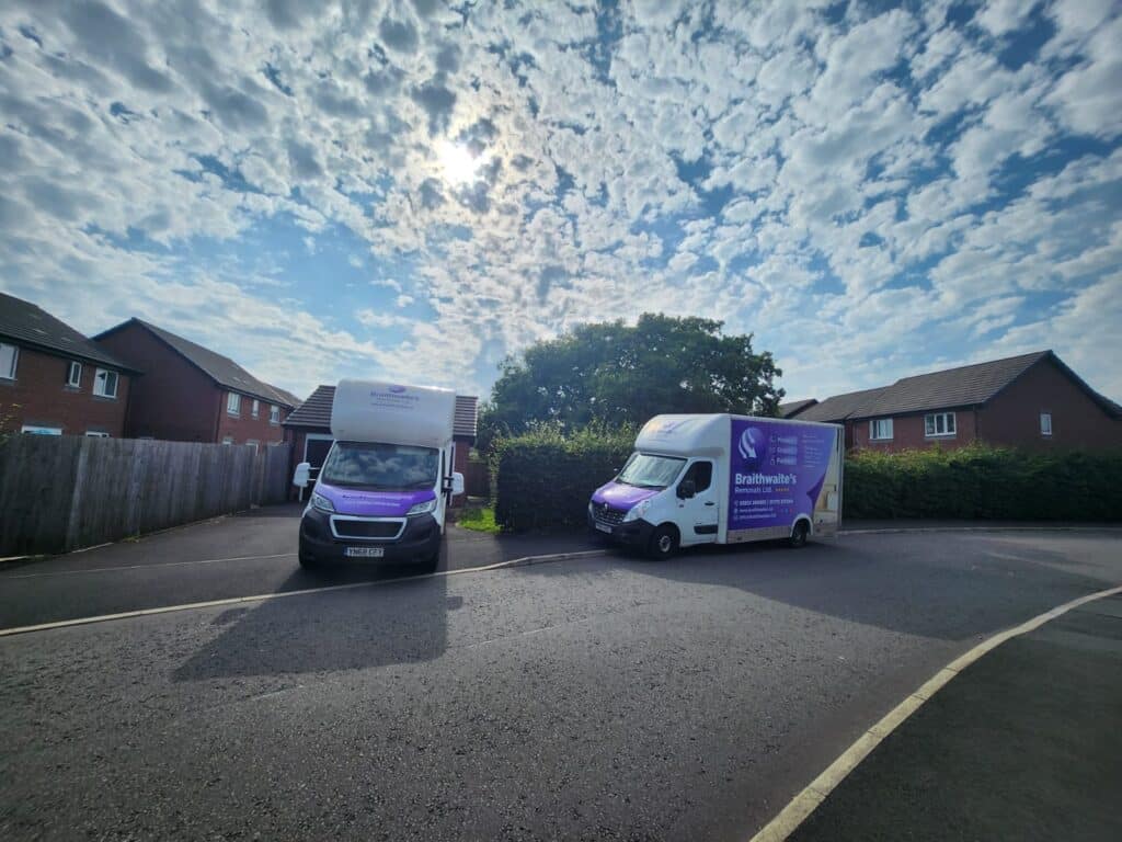 Large house removal – multiple vans and movers handling household items.