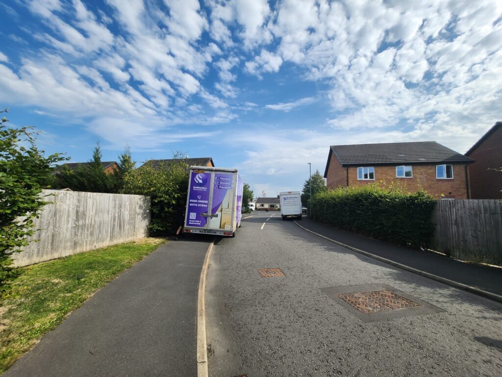 Large house removal – multiple vans and movers handling household items.